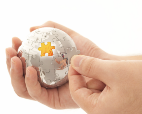 A close-up of hands assembling a spherical jigsaw puzzle, symbolizing the integration and completeness provided by IT solutions in Dallas. The image represents the seamless fit and strategic alignment that effective IT solutions bring to businesses in Dallas.